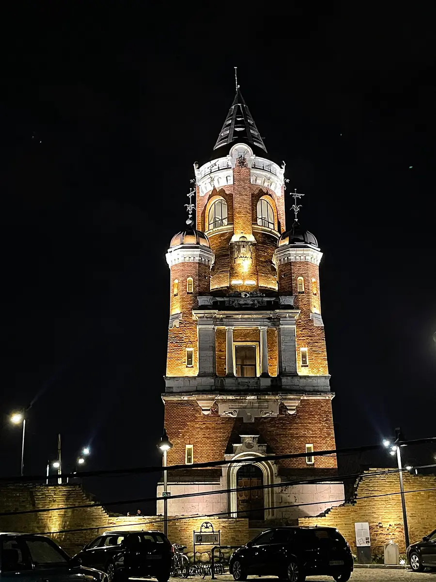 The floodlit brick Gardoš (Millennium) Tower in Zemun rising above the old fortress wall at night