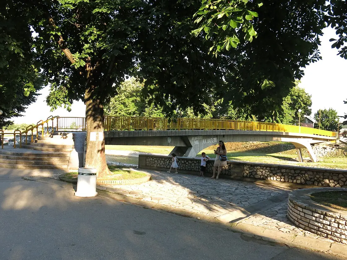 A footbridge over the Kolubara river in central Valjevo with people walking along the riverside path