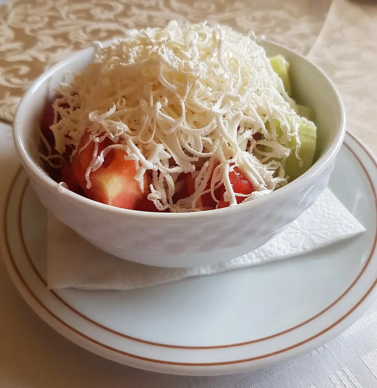 Shopska salad in Belgrade with grated white cheese over tomato, cucumber and pepper