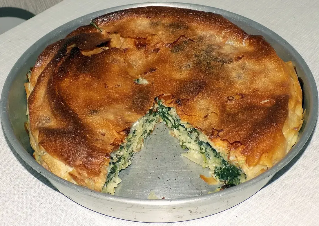 A homemade spinach and cheese pie, golden filo cut into squares