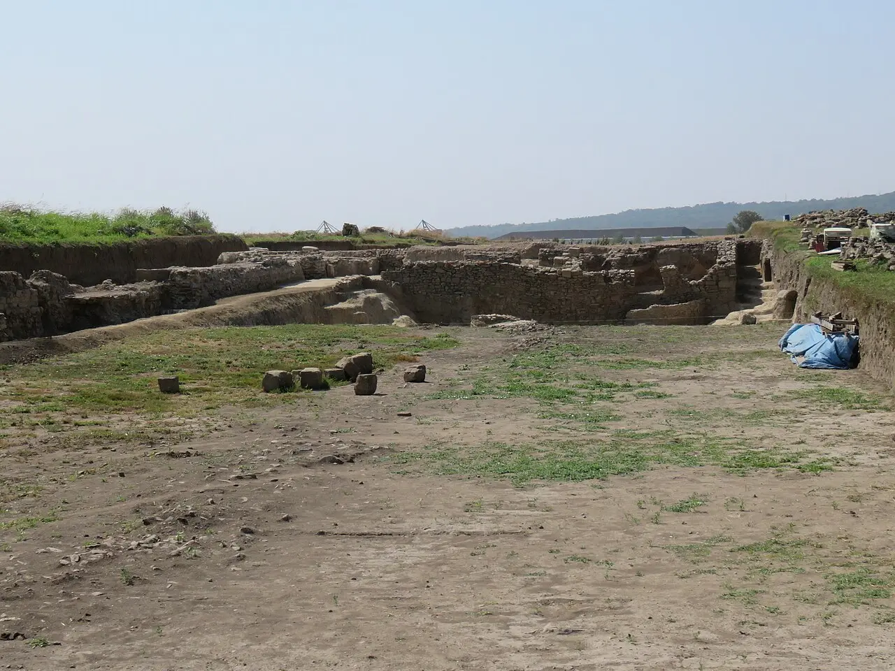 Open excavation trenches near the amphitheatre at Viminacium with visitors on a path