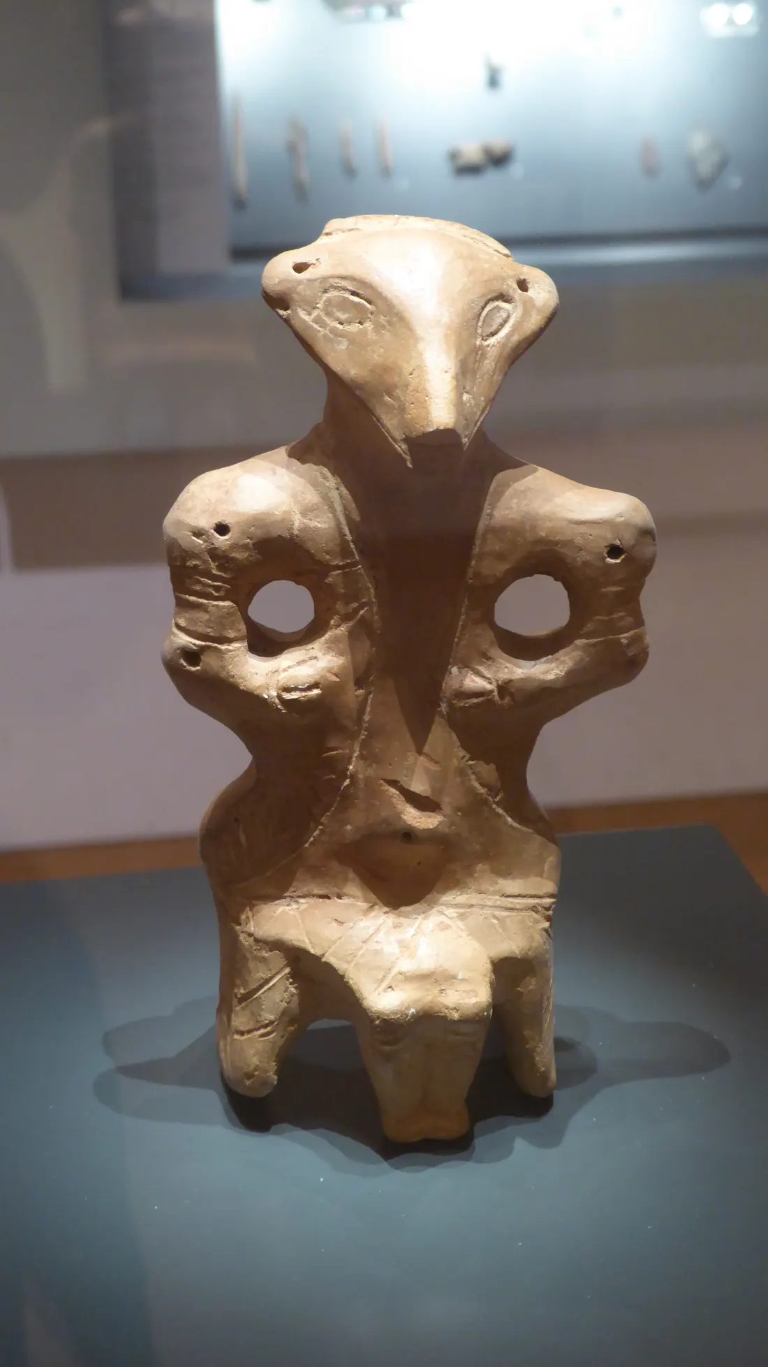 A carved Vinca-culture clay figure with an elongated head and mask-like face, now held in the Ashmolean Museum, Oxford