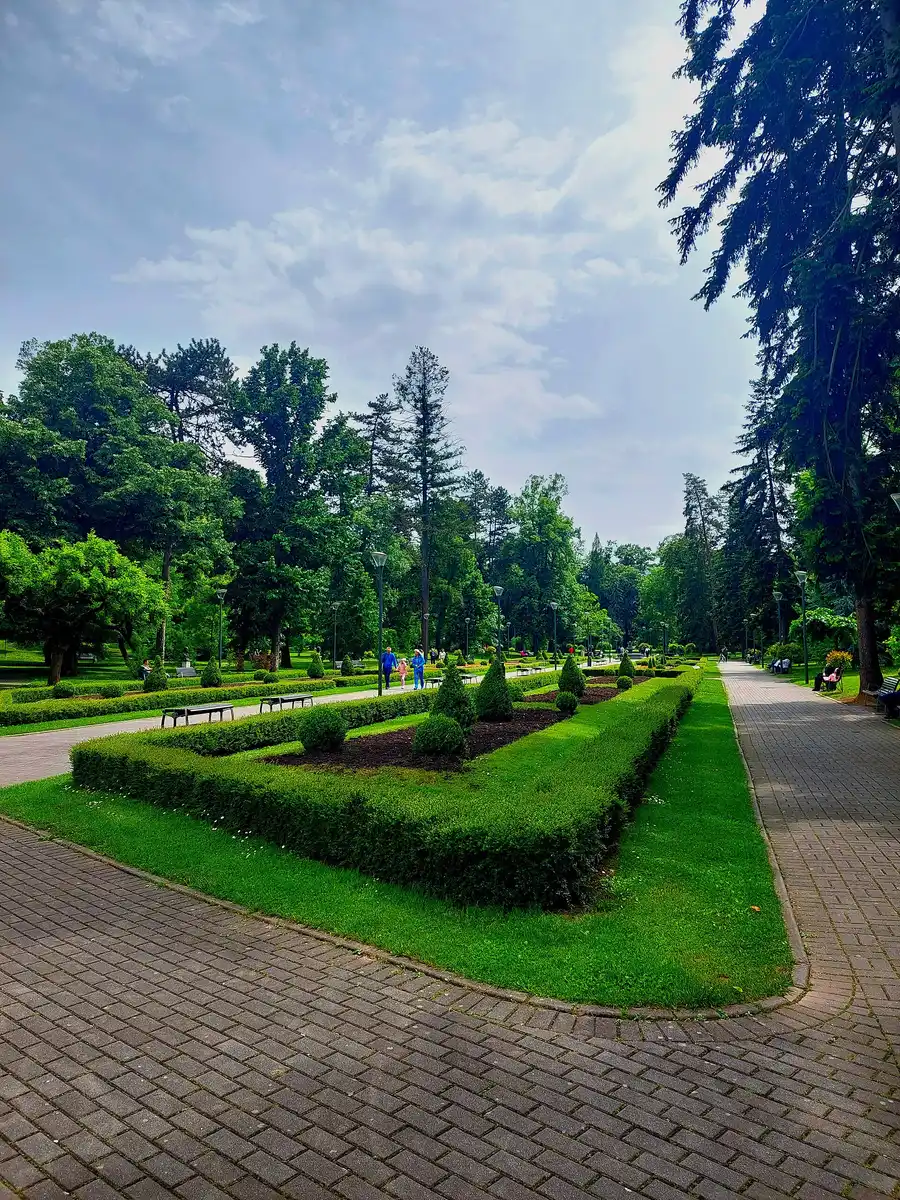 The tree-lined promenade through the central park in Vrnjacka Banja with benches and walkers