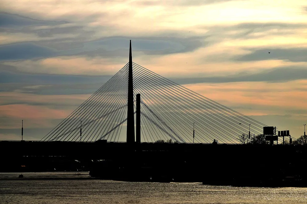 The cable-stayed Ada Bridge over the Sava in Belgrade in silhouette at golden hour, the crossing out of the city heading southwest